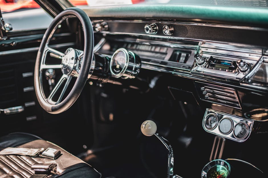 A detailed view of a classic car's interior featuring a vintage dashboard and steering wheel